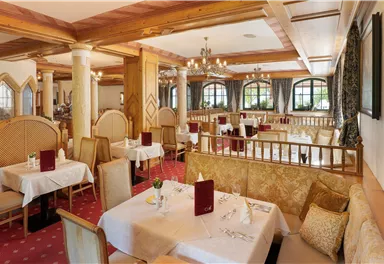 An elegant restaurant with wooden decor and stylish tables. The atmosphere is cozy and inviting.