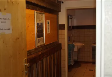 Ein Blick in einen Flur mit Holzverkleidung und einem Waschraum. Der Raum ist hell erleuchtet und gut gepflegt.