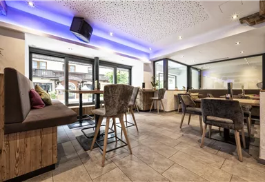 A modern restaurant with elegant interior and bright light. The design is inviting with comfortable seating and large windows.