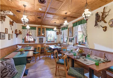 Ein gemütliches Restaurant mit Holzdekor und rustikalem Charme. Die Tische sind ordentlich gedeckt und die Wände sind mit Erinnerungsstücken dekoriert.