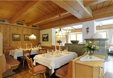 Ein gemütliches Restaurant mit Holzvertäfelung und eleganten Tischen. Die warmen Farben und die einladende Atmosphäre schaffen einen angenehmen Speiseort.