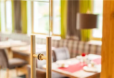 Ein modernes Restaurant mit einer einladenden Atmosphäre. Der Blick zeigt elegantes Mobiliar und einen hellen, freundlichen Raum.