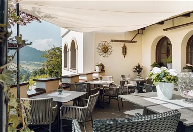 A cozy terrace with high-quality furniture and a view of the landscape. The space is bright and inviting, perfect for a relaxing time outdoors.