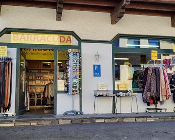 A store named "Barracuda" is visible. Various belts and clothing items are hanging in front.