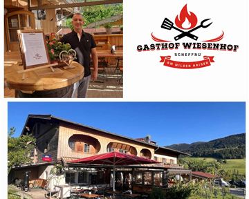 An inviting inn with a cozy restaurant area and a beautiful outdoor terrace. In the background, the Wiesenhof inn can be seen, surrounded by green landscape.
