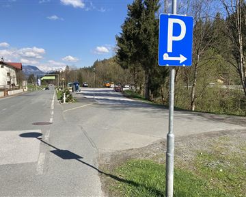 A parking lot is marked, with an arrow pointing to the right. In the background, trees and a quiet place can be seen.