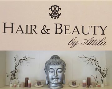 A stylish sign with the inscription "Hair & Beauty by Attila". Below it stands a Buddha statue, surrounded by decorative candles and branches.