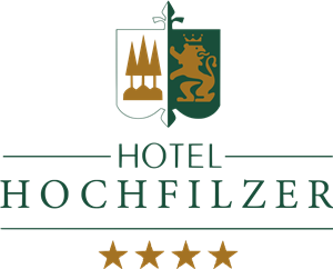 Das Logo des Hotels Hochfilzer zeigt ein Wappen mit einem Baum und einem Löwen. Es ist eine elegante Darstellung, die die 5-Sterne-Bewertung betont.