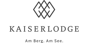 A stylish logo of the KaiserLodge. The slogan reads: "At the mountain. By the lake."
