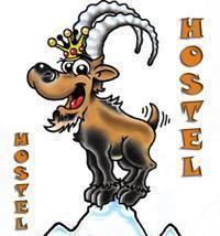 Ein lustiges Maskottchen in Form einer Ziege mit einer Krone. Die Ziege steht auf einem Berg und ist Teil des Logos eines Hostels.