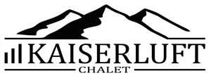 A stylized logo of Kaiserluft Chalet. The depiction shows mountains in black and white.
