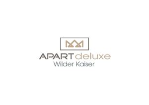 An elegant logo for "APART deluxe Wilder Kaiser". The design is simple and modern, with a combination of golden and grey colors.