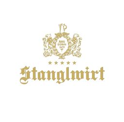 An elegant logo with the name "Stanglwirt" in golden letters. Above it, there is a coat of arms featuring a crown and the year 1609.