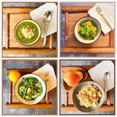 Various healthy dishes on wooden trays. They include green soup, fruit salad, mixed salad, and quinoa with nuts.