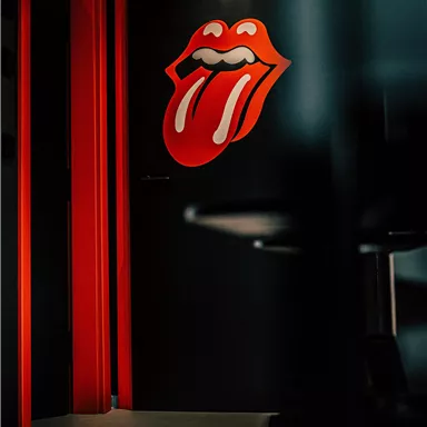 A black door with a striking red lips logo. The room has a modern and artistic atmosphere.