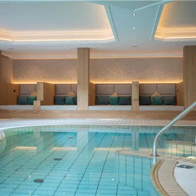 An elegant indoor pool with a bright and modern design. Relaxation areas with comfy loungers invite you to stay.