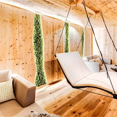 A modern room with wooden paneling and hanging chairs. Green plant accents add a fresh touch to the ambiance.