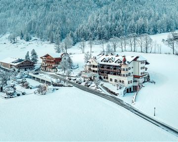 A picturesque winter landscape with snow-covered buildings. The surroundings are quiet and surrounded by mountains.
