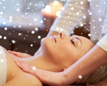 A woman receives a relaxing massage. Gentle snowflakes have a calming effect in the background.