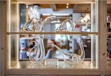 Eine elegante Vitrine mit fünf schönen Glasobjekten. Die Kunstwerke sind modern und transparent und zeigen verschiedene Formen.