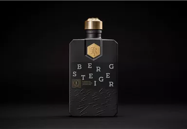 Eine stilvolle Flasche mit schwarzem Design und goldenen Akzenten. Der Text auf der Flasche deutet auf einen hochwertigen Inhalt hin.