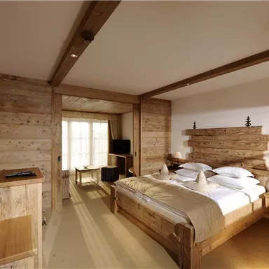 Ein gemütliches Schlafzimmer mit Holzmöbeln und einem großen Bett. Der Raum ist hell und einladend, mit Blick auf einen sonnigen Bereich.