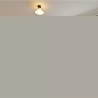 A bright bedroom with a double bed and a cozy armchair. Large windows provide plenty of daylight.