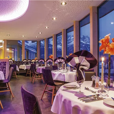 An elegant restaurant with table decoration and a view of the mountains. The atmosphere is stylish and inviting.