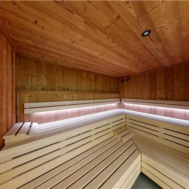 A peaceful sauna with wooden walls and cozy benches. It offers a relaxing space for resting and feeling good.