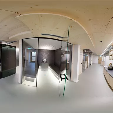 A modern space with glass shower cabins and a bright, welcoming atmosphere. On the wall, folded towels are stacked on a shelf.