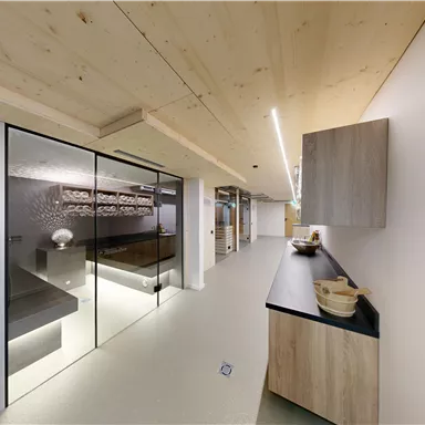 A modern room with wooden details and an elegant, minimalist design. The glass doors and simple furnishings create an inviting atmosphere.