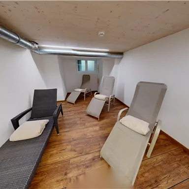 A quiet room with loungers and a light wooden floor. The walls are simple and tidy, ideal for relaxing.