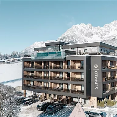 Ein modernes Hotel im Schnee mit Bergblick. Die Landschaft ist winterlich und friedlich.