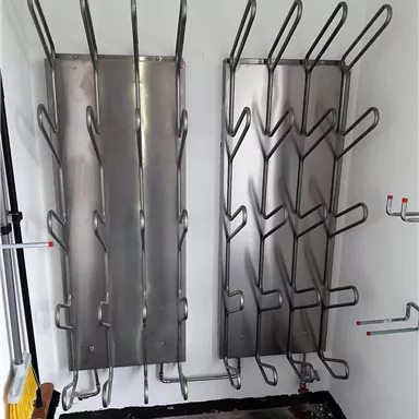 Zwei Metallkleiderständer mit mehreren Haken sind an der Wand montiert. Der Raum wirkt sauber und funktional.