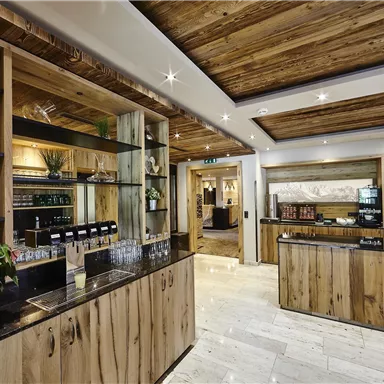 Ein moderner Empfangsbereich mit Holzregalen und eleganten Details. Pflanzen und dekorative Elemente schaffen eine einladende Atmosphäre.