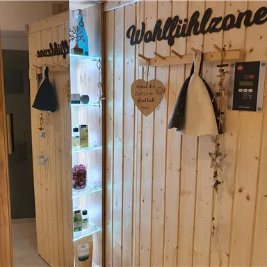 An inviting area with wooden-paneled walls. There are shelves with care products and decorative elements for a feel-good atmosphere.