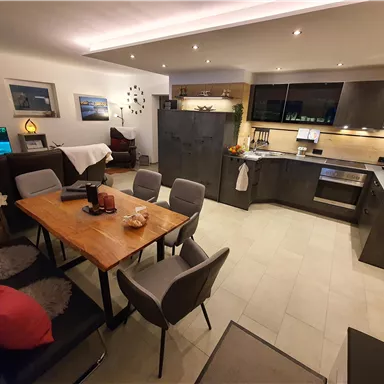 Eine moderne Küche mit einem Essbereich und komfortablen Stühlen. Der Raum ist freundlich und gut beleuchtet, ideal für geselliges Beisammensein.