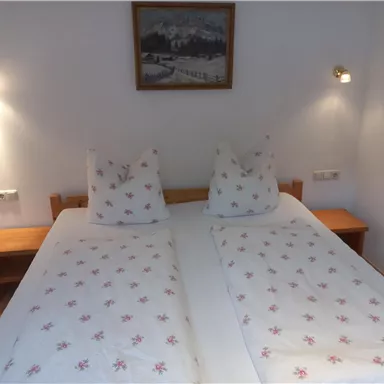 Ein gemütliches Schlafzimmer mit zwei Einzelbetten und weichen Kissen. Sanfte Beleuchtung schafft eine einladende Atmosphäre.