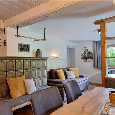 An inviting living room with comfortable sofas and a wooden table. Soft colors and decorative plants create a cozy atmosphere.