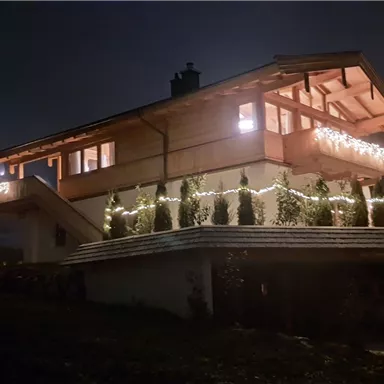 A beautifully lit house at night.
Surrounded by trees and a peaceful atmosphere.