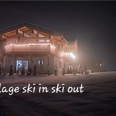 A cozy chalet in the snow, festively decorated. The surroundings are quiet and wintry.