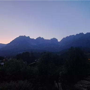 An impressive mountain landscape at sunset. The silhouettes of the mountains stand out against the colorful sky.