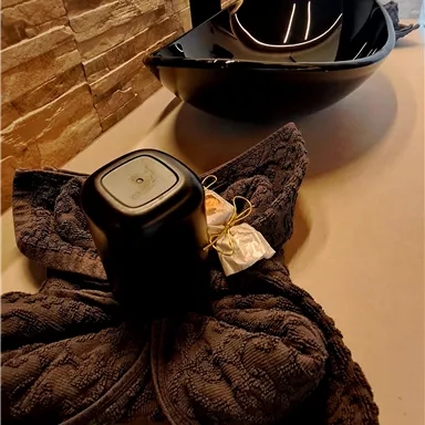 A modern sink with an elegant design and a decorative towel. The colors are stylish and fit well with the bathroom environment.