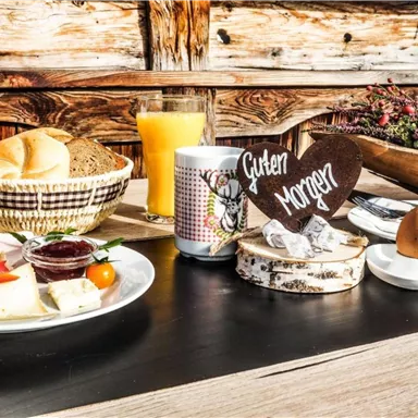 A hearty breakfast with rolls, eggs, and fresh orange juice. On the table, there is a wooden sign with the inscription "Good Morning".