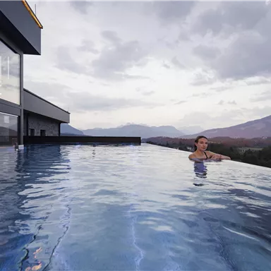 Ein wunderschöner Infinity-Pool mit Blick auf die Berge. Der Himmel ist bewölkt und die Atmosphäre ist ruhig.