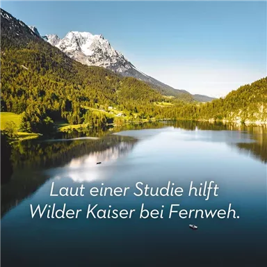 A picturesque landscape with mountains and a tranquil lake. The green meadow and the snow-capped peaks create a beautiful contrast.