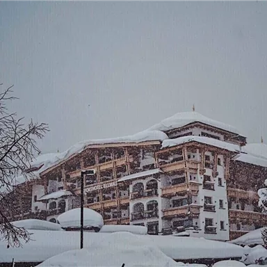 A large building in a snowy landscape. The winter snow covers roofs and trees.