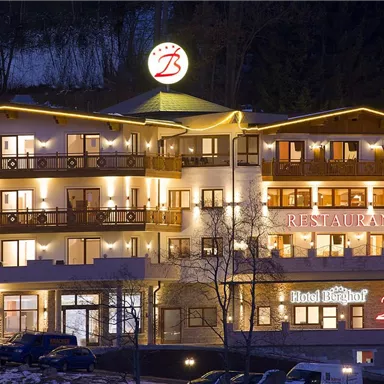 A cozy hotel with illuminated balconies and an inviting restaurant. The facade is designed to be modern and friendly.