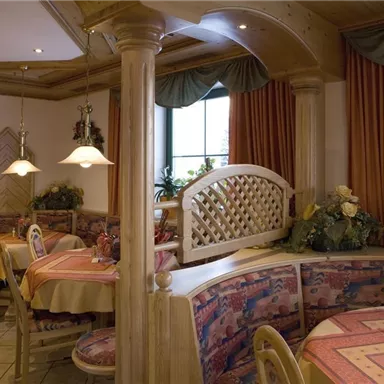 Ein gemütliches Restaurant mit Holzinterieur und bunten Tischdecken. Die Einrichtung ist einfach und einladend.