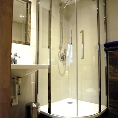 A modern shower with crystal-clear walls and elegant design. The space is bright and functionally furnished.